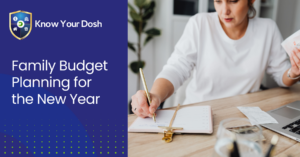 woman at desk with pen and paper in hand working on family budget