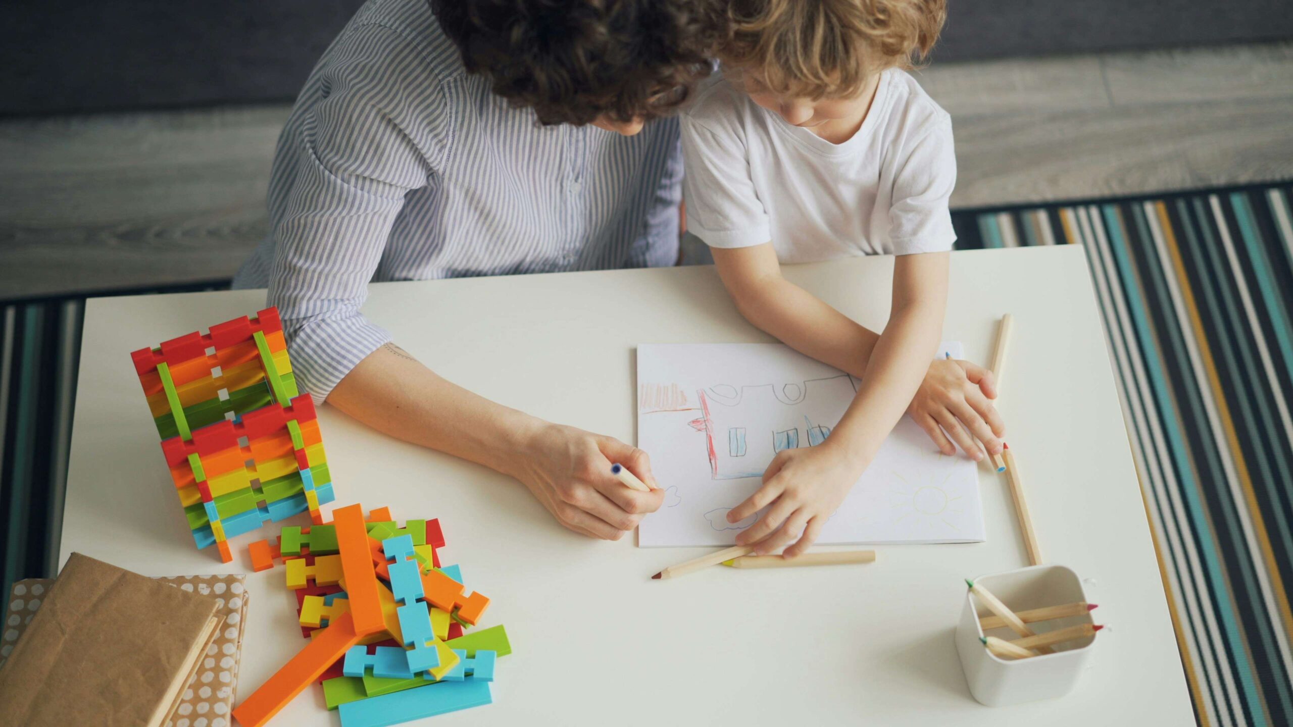 mother and child at table with building blocks and colouring pencils