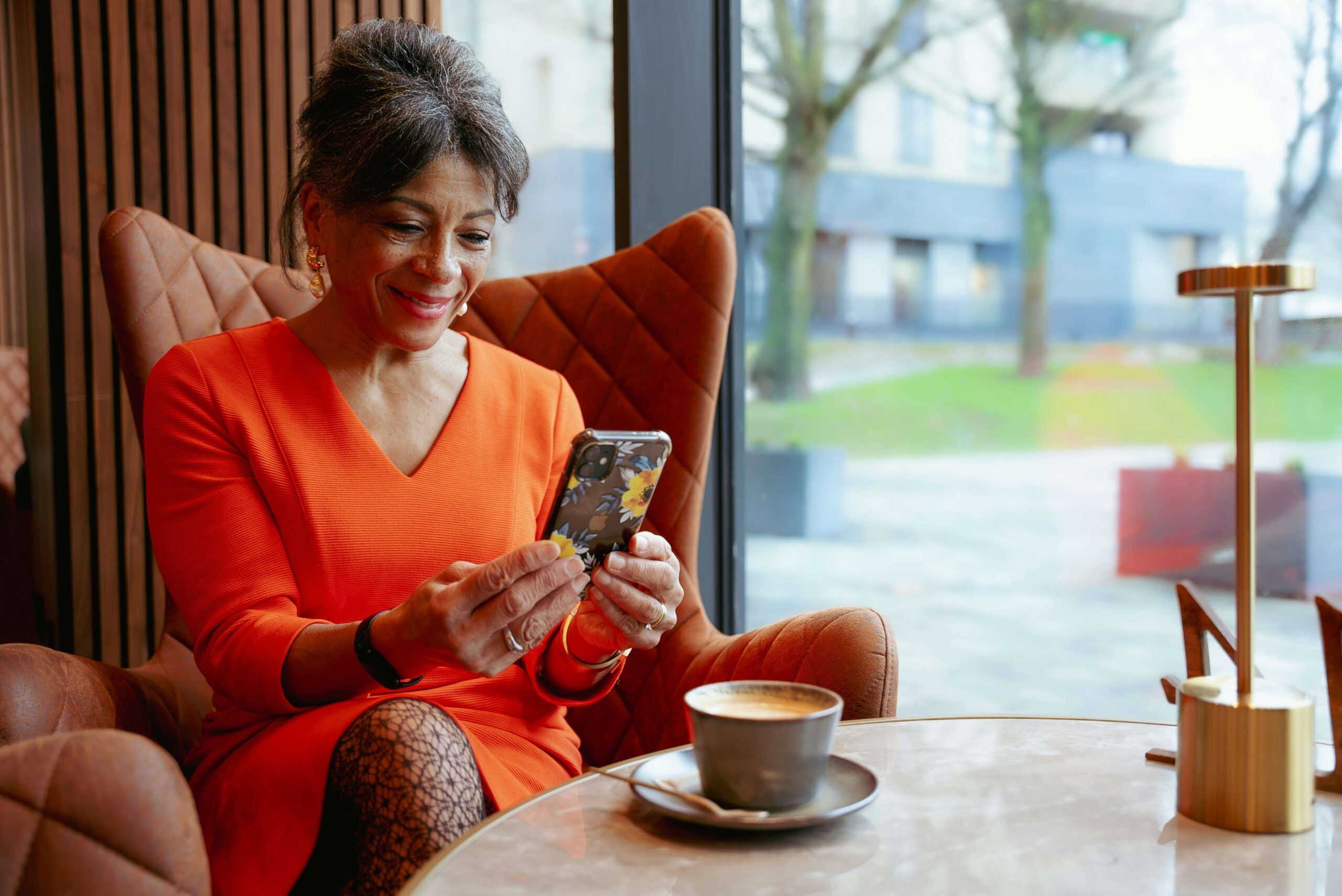 woman looking at phone in a cafe and smiling